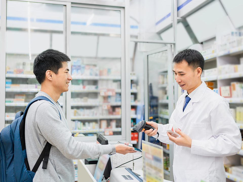 Man at pharmacy making a payment with his smartphone